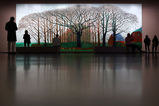 Visitors look at the painting "Bigger Trees Near Warter Or/Ou Peinture Sur Le Motif Pour Le Nouvel Age Post-Photographique, 2007" by British painter David Hockney during a press visit ahead of the opening of the exhibition "David Hockney 25" at the Fondation Louis Vuitton in Paris, France, April 8, 2025. REUTERS/Gonzalo Fuentes