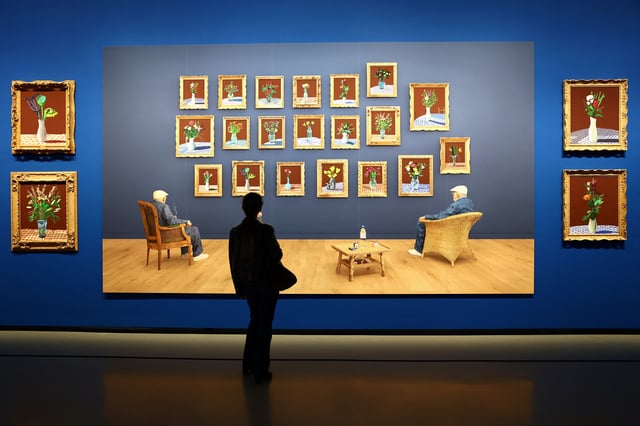 A visitor looks at the painting "25th June 2022, Looking at the Flowers (Framed)" by British painter David Hockney during a press visit ahead of the opening of the exhibition "David Hockney 25" at the Fondation Louis Vuitton in Paris, France, April 8, 2025. REUTERS/Gonzalo Fuentes