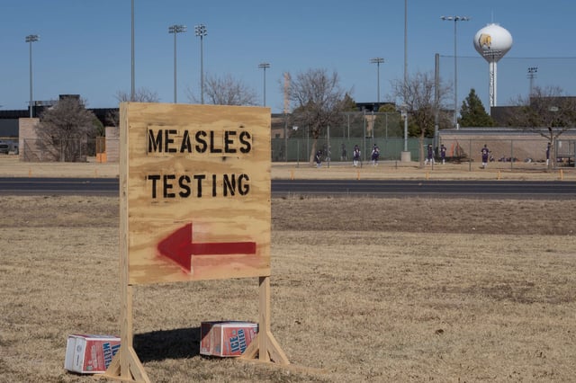 Signs point the way to measles testing in the parking lot of the Seminole Hospital District across from Wigwam Stadium on February 27, 2025, in Seminole, Texas.