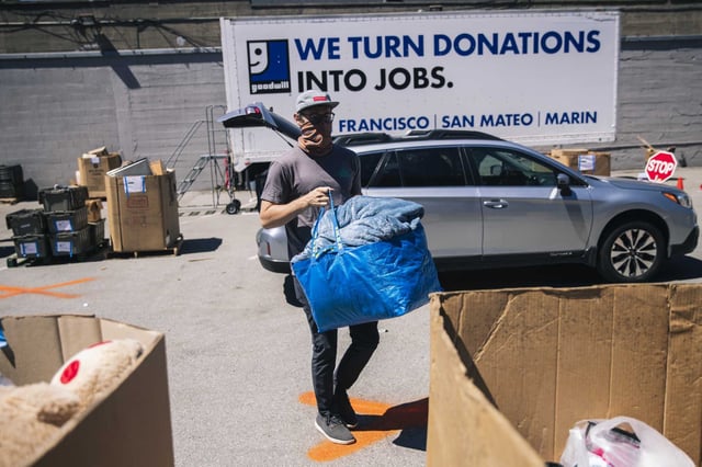A customer donates a bag of soft goods at a Goodwill drop-off donation site in San Francisco in 2020. The nonprofit organization is permanently closing two Bay Area facilities, resulting in dozens of layoffs.
