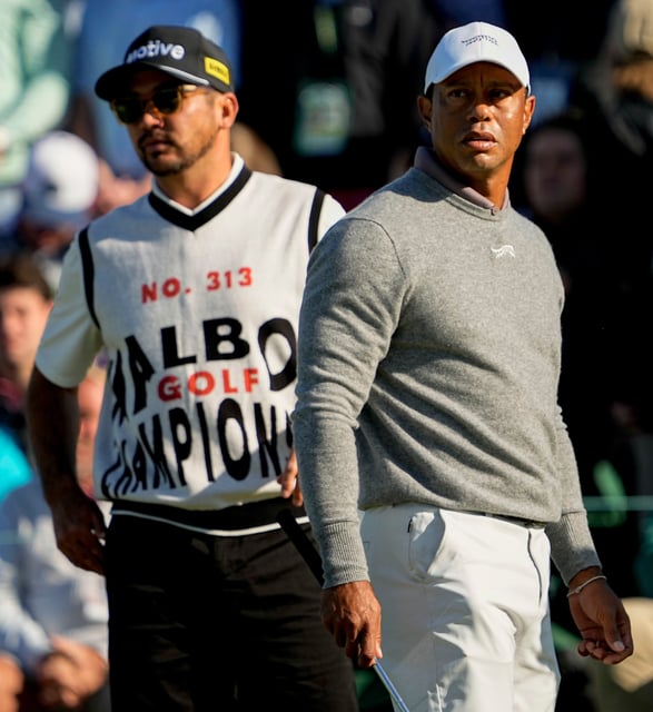 Tiger Woods and Jason Day check the scoreboard after finishing on no. 18 during the completion of the first round of the Masters Tournament.