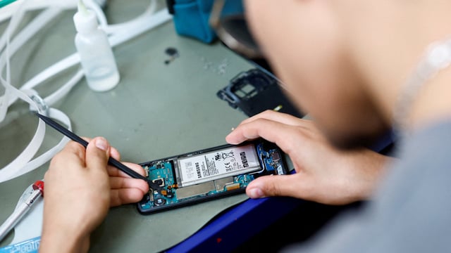 A smartphone repair technician works on a Samsung Electronics' Galaxy S8 in Saint-Sebastien-sur-Loire