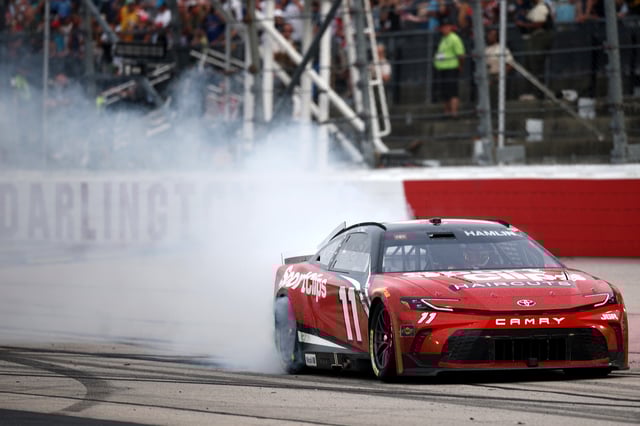 Denny Hamlin, driver of the #11 Sport Clips Haircuts Toyota, celebrates with a burnout after winning the NASCAR Cup Series Goodyear 400 at Darlington Raceway on April 06, 2025 in Darlington, South Carolina.