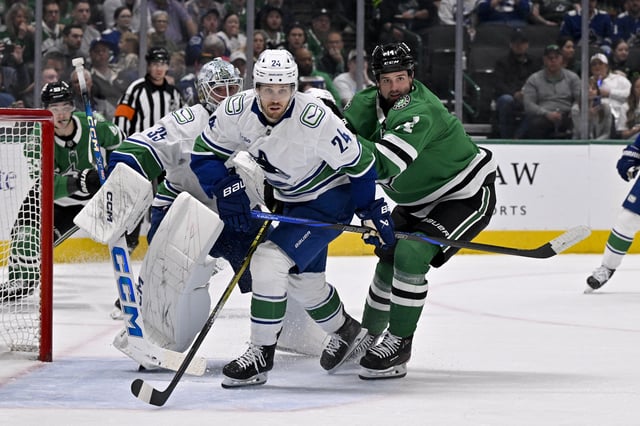 Apr 8, 2025; Dallas, Texas, USA; Vancouver Canucks center Pius Suter (24) and Dallas Stars left wing Jamie Benn (14) chase the puck in the Dallas zone during the second period at the American Airlines Center. Mandatory Credit: Jerome Miron-Imagn Images