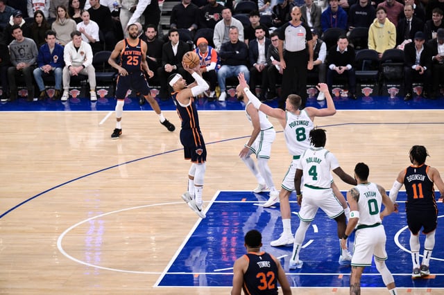 Apr 8, 2025; New York, New York, USA; New York Knicks guard Josh Hart (3) shoots the ball while being defended by Boston Celtics center Kristaps Porzingis (8) during the first half at Madison Square Garden. Mandatory Credit: John Jones-Imagn Images
