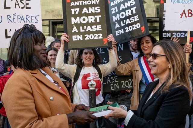 Devant l'Assemblée nationale, remise du rapport sur les dysfonctionnements de l'ASE par la députée Isabelle Santiago (à droite) aux membres du Comité de vigilance des enfants placés, le 7 avril 2025.
