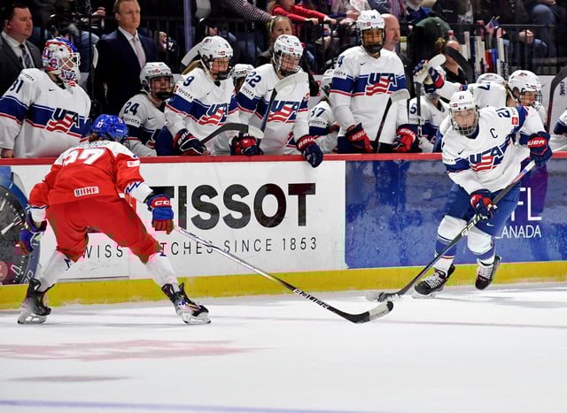 Hilary Knight #21 of United States of Czechia looks for an option to pass to while Tereza Radova #27 of Czechia restricts her forward progress in front of the USA bench during the 2024 IIHF Women&#39;s World Championship at Adirondack Bank Center on April 05, 2024 in Utica, New York.