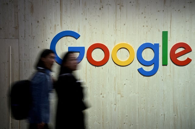 People walk next to a Google logo during a trade fair in Hannover Messe, in Hanover, Germany, April 22, 2024.  REUTERS/Annegret Hilse/File Photo