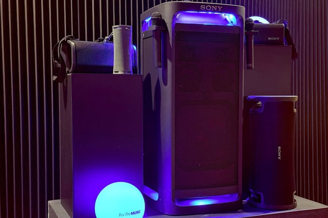 A Sony Bluetooth speakers display featuring multiple black speakers bathed in blue light.