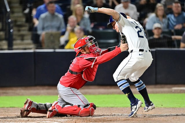 TAMPA, FLORIDA - APRIL 08: Travis d&#39;Arnaud #25 of the Los Angeles Angels tags Jake Mangum #28 of the Tampa Bay Rays out at home plate in the ninth inning at George M. Steinbrenner Field on April 08, 2025 in Tampa, Florida. (Photo by Julio Aguilar/Getty Images) *** BESTPIX ***