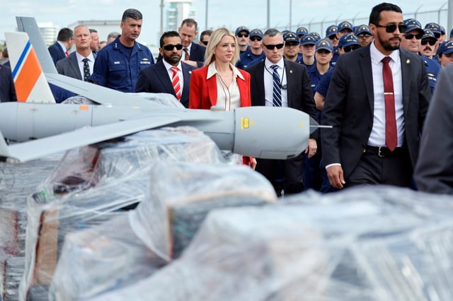 U.S. Attorney General Pam Bondi and FBI Director Kash Patel walk past pallets of shrink-wrapped narcotics and a drone used in the investigations as they arrive for a news conference on Wednesday, April 9, 2025, at Port Everglades held to announce the seizure of more than $509 million in illegal narcotics weighing more than 48,400 pounds. (Amy Beth Bennett / South Florida Sun Sentinel)