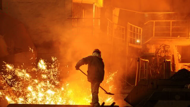Man is working in the splashing molten iron