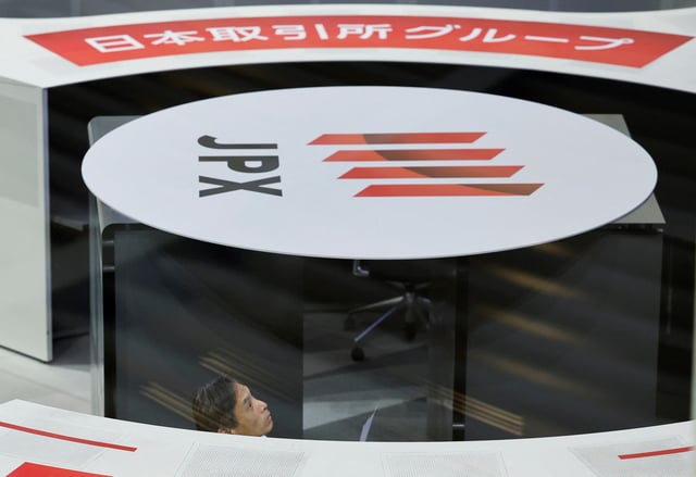 A staff of the Tokyo Stock Exchange (TSE) looks at a stock quotation board after a ceremony marking the end of trading in 2024 at the TSE in Tokyo, Japan December 30, 2024. REUTERS/Kim Kyung-Hoon/File Photo