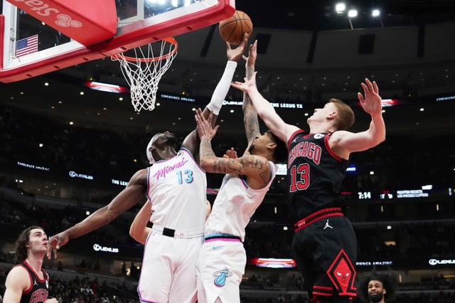 Miami Heat center Bam Adebayo, left, battles for a rebound against center Kel&#39;el Ware, center, and Chicago Bulls guard Kevin Huerter during the first half of an NBA basketball game in Chicago, Wednesday, April 9, 2025. (AP Photo/Nam Y. Huh)