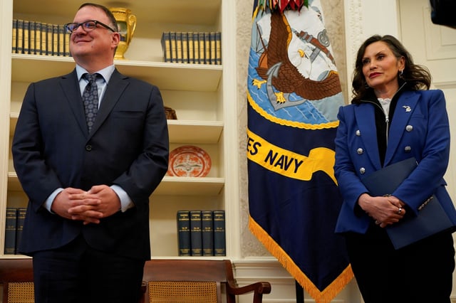 Michigan Governor Gretchen Whitmer stands next to Michigan House Speaker Matt Hall, as U.S. President Donald Trump (not pictured) signs executive orders and proclamations, in the Oval Office at the White House in Washington, DC, on April 9, 2025.