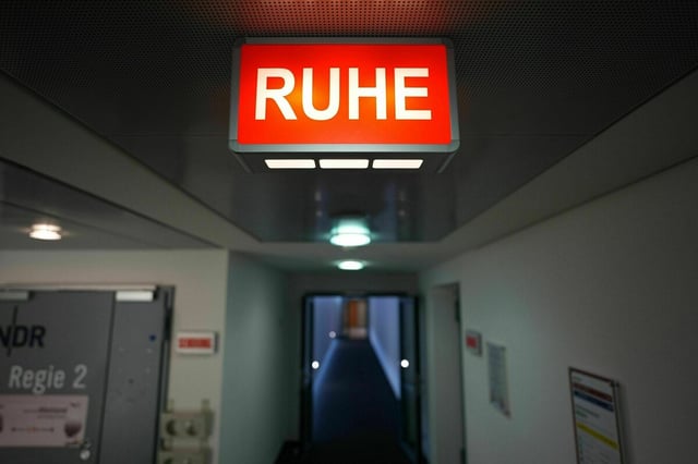 Eine rote Lampe mit der Aufschrift "Ruhe" hängt an der Decke eines Flures