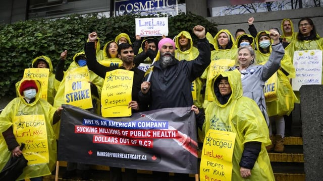 Canada NDP leader Jagmeet Singh poses for a photo with striking LifeLabs workers, BC General Employees' Union members and NDP candidate Sukhi Singh Sahota, centre left, on the picket line during a campaign stop in Vancouver, British Columbia, Canada, on April 8. (AP)
