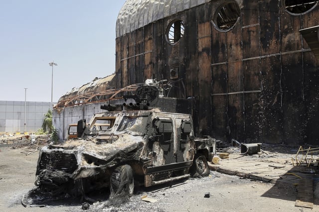 A burned military vehicle sits at Khartoum international airport a day after it was recaptured from the paramilitary Rapid Support Forces (RSF), in Khartoum, Sudan, Thursday, March 27, 2025. (AP Photo)