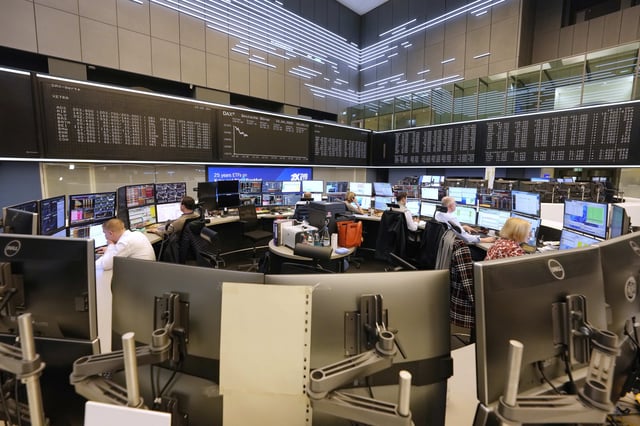 Traders work on the trading floor of the Frankfurt Stock Exchange in front of a display board showing the DAX stock index in Frankfurt, Germany, the day after U.S. President Donald Trump announced a 90-day pause on 'reciprocal' tariffs, Thursday, April 10, 2025. (AP Photo/Martin Meissner)