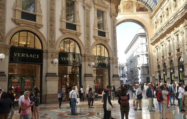 People stroll in front of Versace's flagship shop at Galleria Vittorio Emanuele II in Milan, Italy, September 25, 2018. REUTERS/Stefano Rellandini/ File Photo