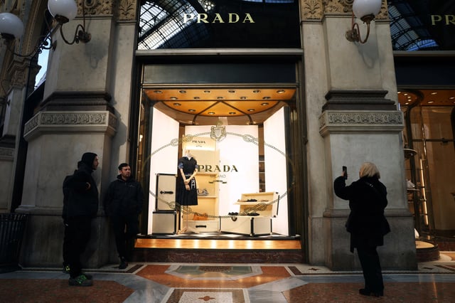 People stand outside a Prada store in Galleria Vittorio Emanuele II in Milan, Italy, January 10, 2025. REUTERS/Claudia Greco/ File Photo