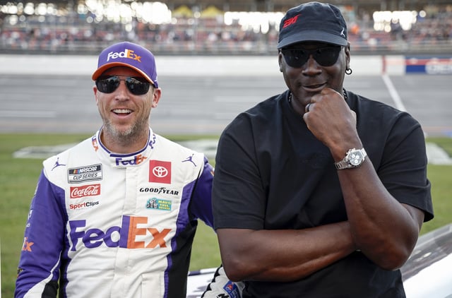 Co-owners of 23XI Racing, Denny Hamlin, driver of the #11 FedEx One Rate Toyota, and NBA Hall of Famer, Michael Jordan talk on the grid after the NASCAR Cup Series YellaWood 500 at Talladega Superspeedway on October 06, 2024 in Talladega, Alabama.