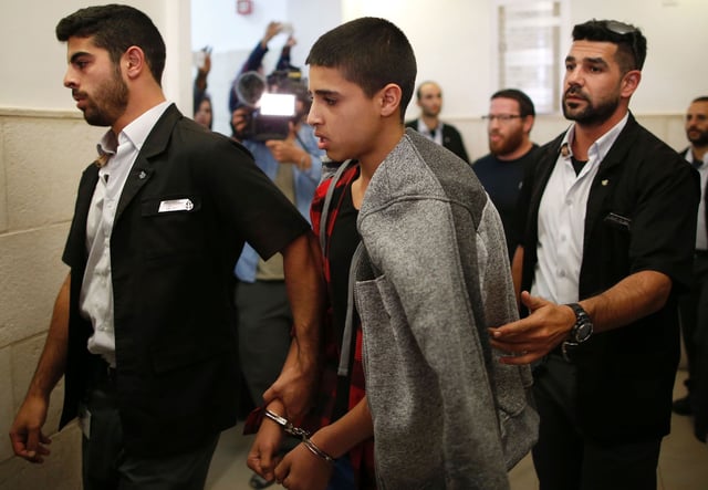 Ahmed Manasra (C), a 14-year old Palestinian boy, convicted of the attempted murder of two Israelis in a stabbing in October 2015, leaves the District Court in Jerusalem after his sentencing hearing on November 7, 2016.
The court sentenced Manasra to 12 years in jail for the knife attack, his lawyer said. / AFP / AHMAD GHARABLI        (Photo credit should read AHMAD GHARABLI/AFP via Getty Images)