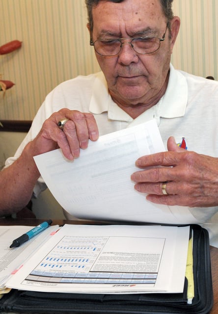 Retired engineer Bill Jenkins looks over documents concerning his investment in Reef's Income & Development Fund II at his home in Orlando, Florida, October 31, 2014. Picture taken October 31, 2014. To match Special Report USA-PRIVATEPLACEMENTS/OILANDGAS REUTERS/Steve Nesius (UNITED STATES - Tags: ENERGY BUSINESS)