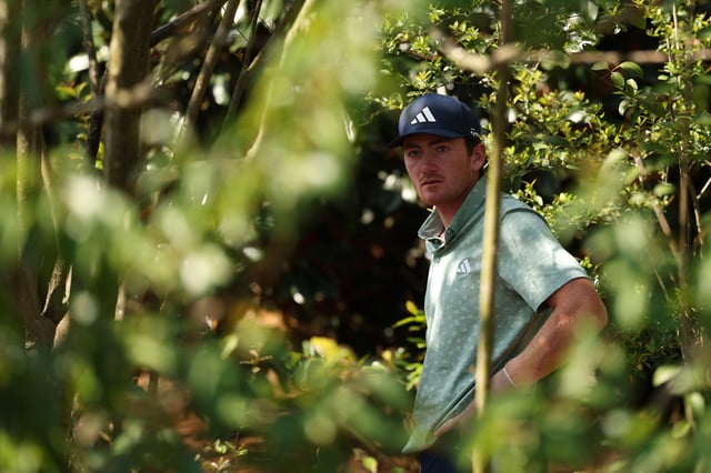 Nick Dunlap of the United States prepares to play a shot from the trees on the fifth hole during the first round of the 2025 Masters Tournament at Augusta National Golf Club on April 10, 2025 in Augusta, Georgia.