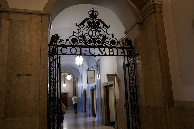 People walk down a hallway on campus at Columbia University in New York City, U.S., April 8, 2025. REUTERS/Ryan Murphy/File Photo