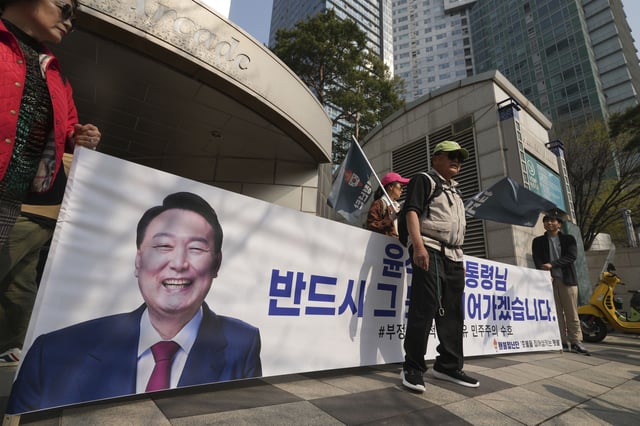 Supporters of recently removed South Korean President Yoon Suk Yeol hold a banner with a picture of Yoon near his private residence in Seoul, South Korea, Friday, April 11, 2025. The part of letters read "President Yoon Suk Yeol." (AP Photo/Lee Jin-man)