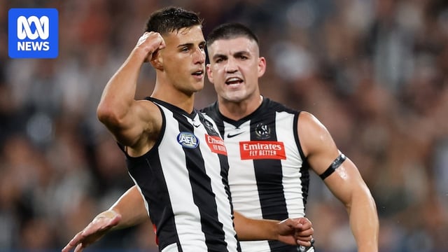 A Collingwood AFL player pumps his fist after kicking a goal.