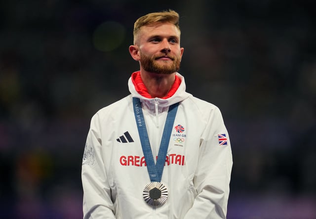 Paris 2024 Olympics - Athletics - Men's 1500m Victory Ceremony - Stade de France, Saint-Denis, France - August 06, 2024. Silver medaliist Josh Kerr of Britain celebrates with his medal on the podium REUTERS/Aleksandra Szmigiel/File Photo