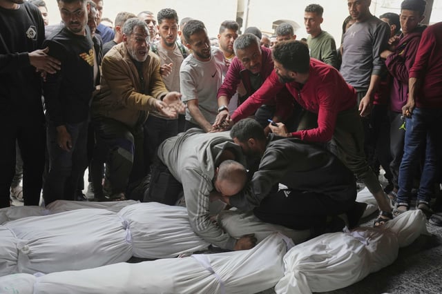 Palestinians mourn over the bodies of their relatives who were killed in an Israeli airstrike in Shijaiyah neighborhood, as they brought to the Baptist Hospital in Gaza City on Wednesday, April 9, 2025. (AP Photo/Jehad Alshrafi)