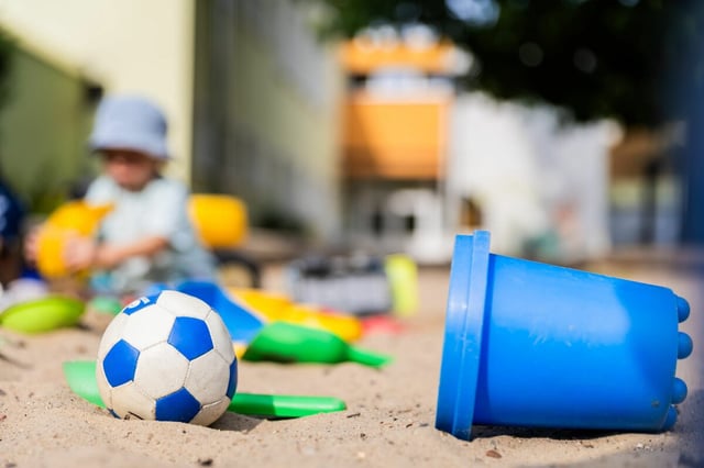 Ein Kind spielt im Sandkasten einer Kita