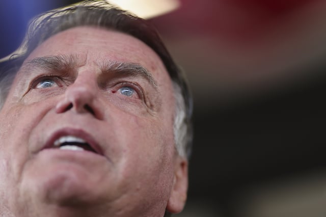 FILE - Brazil's former President Jair Bolsonaro speaks to the media as he arrives at the Brasilia International Airport in Brasilia, Brazil, March 25, 2025. (AP Photo/Luis Nova, File)