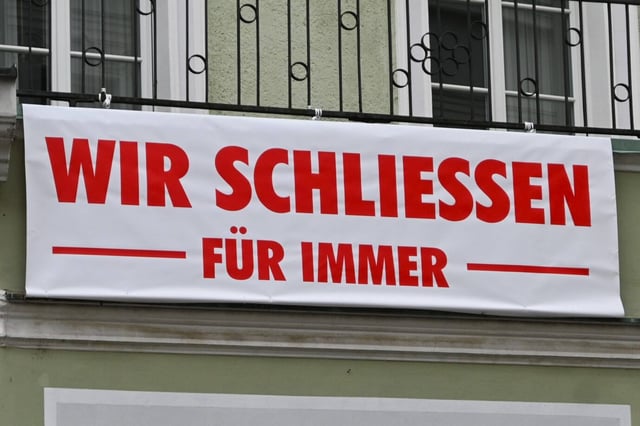 Ein Plakat an einer Hauswand mit der Aufschrift "Wir schließen für immer". Der Insolvenztrend reißt nicht ab.