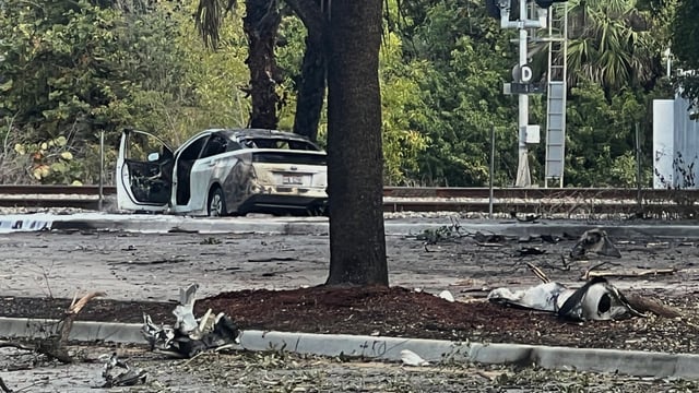 Emergency personnel respond to the area where a small plane crashed on the railroad tracks beneath the overpass near Interstate 95 in Boca Raton
