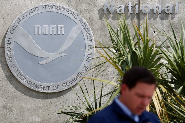 The logo of the National Oceanic and Atmospheric Administration is seen behind Florida Governor Ron DeSantis as he talks to the media during a news conference as Hurricane Dorian approaches the state, at the National Hurricane Center in Miami, Florida, U.S. August 29, 2019.  REUTERS/Marco Bello/File Photo