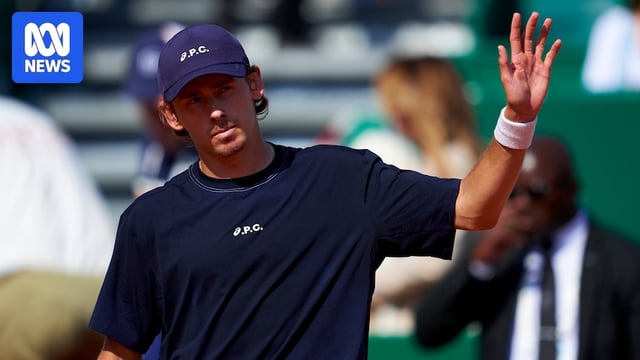 Alex de Minaur waves to the crowd with his left hand