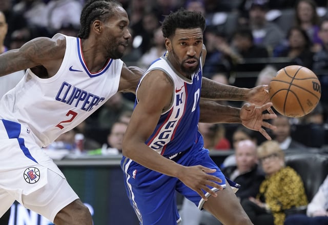 Malik Monk #0 of the Sacramento Kings dribbling the ball has it knocked away from behind by Kawhi Leonard #2 of the LA Clippers during the second half of an NBA basketball game at Golden 1 Center on November 29, 2023 in Sacramento, California
