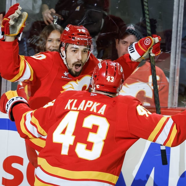 Calgary Flames' Ryan Lomberg (70) celebrates his goal with teammate Adam Klapka (43) during third period NHL hockey action against the Minnesota Wild in Calgary on Friday, April 11, 2025.THE CANADIAN PRESS/Jeff McIntosh