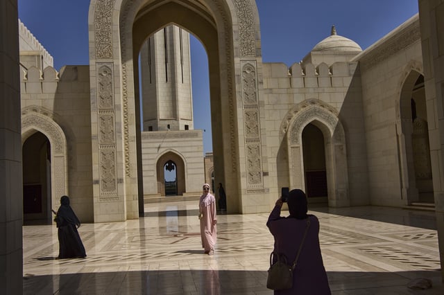 Tourists take photos at the Sultan Qaboos Grand Mosque in Muscat, Oman, Saturday, April 12, 2025. (AP Photo/ Fatima Shbair)