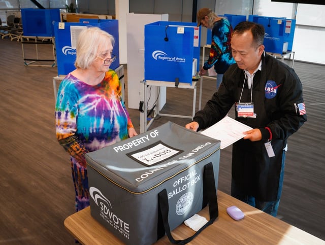 Robert James Morrison and his wife Barbara Morrison of Chula Vista arrived at a vote center at the county Health &amp; Human Services Agency on Tuesday, April 8, 2025, in Chula Vista, to vote in the special election to fill the vacancy for District 1 county supervisor. Submitting Morrison’s ballot to the sealed ballot box is poll worker Mike Pham. (Nelvin C. Cepeda / The San Diego Union-Tribune)