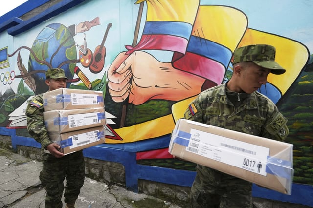 Army soldiers carry electoral kits at a polling station in preparation for Sunday's presidential runoff election, in Quito, Ecuador, Saturday, April 12, 2025. (AP Photo/Dolores Ochoa)