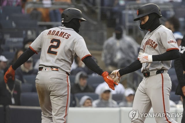 Lee Jung-hoo of the San Francisco Giants (R) greets teammate Willy Adames after scoring against the New York Yankees during a Major League Baseball regular-season game at Yankee Stadium in New York on April 12, 2025, in this Associated Press photo. (Yonhap)