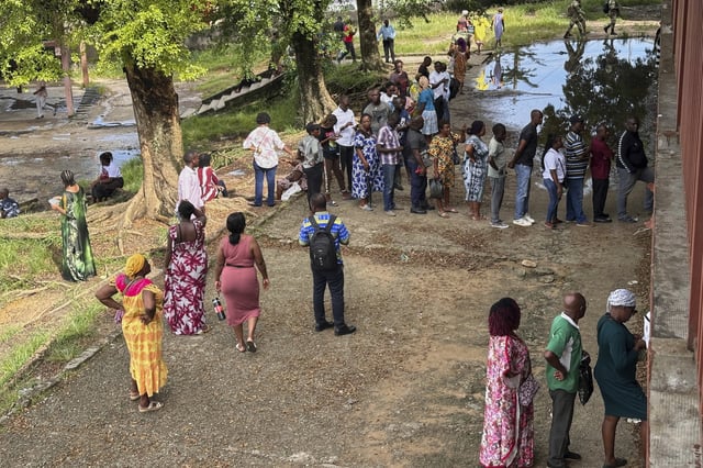 Voters queue to cast their votes for the presidential elections outside a polling station, in Liberville, Gabon, Saturday, April 12, 2025. (AP Photo/Betines Makosso)