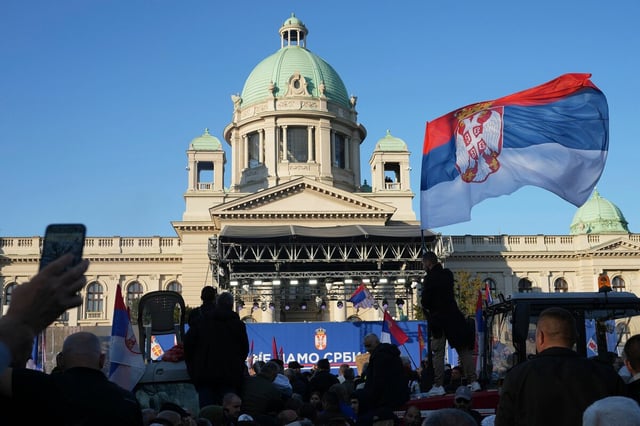 Protestmenge mit Fahnen vor einer Bühne