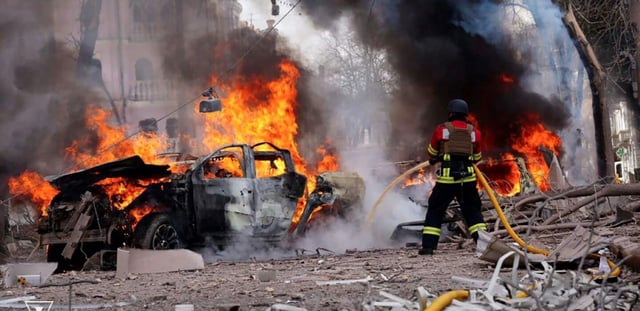 Un pompier tente d'éteindre l'incendie d'une voiture, après une attaque russe à Soumy, dans le nord-est de l'Ukraine, le 13 avril 2025