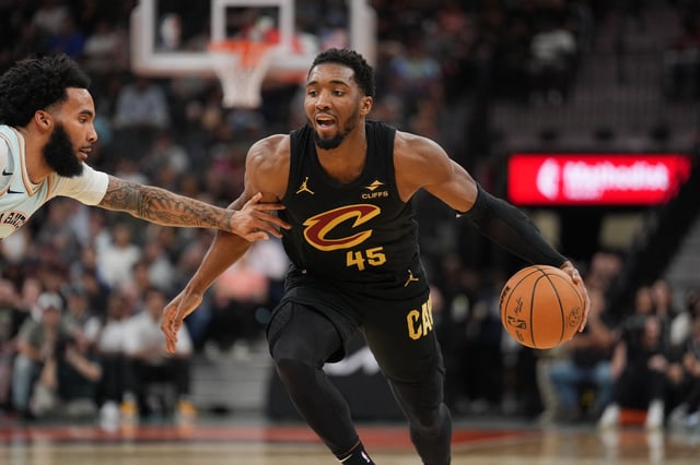 Apr 4, 2025; San Antonio, Texas, USA;  Cleveland Cavaliers guard Donovan Mitchell (45) dribbles against San Antonio Spurs forward Julian Champagnie (30) in the first half at Frost Bank Center. Mandatory Credit: Daniel Dunn-Imagn Images/File Photo